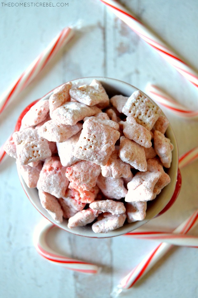 Bowl of peppermint candy cane muddy buddies surrounded by candy canes