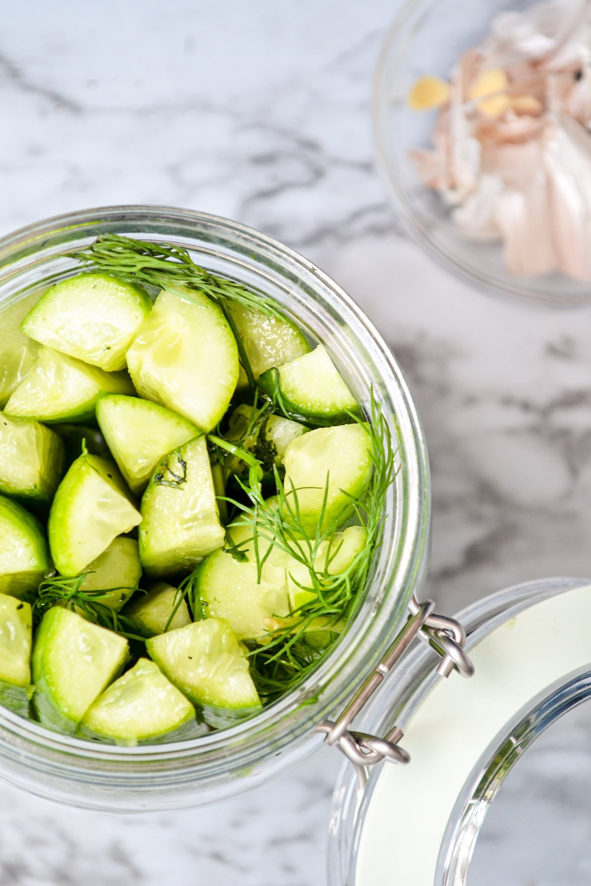 A jar of refrigerator pickles in a glass jar.