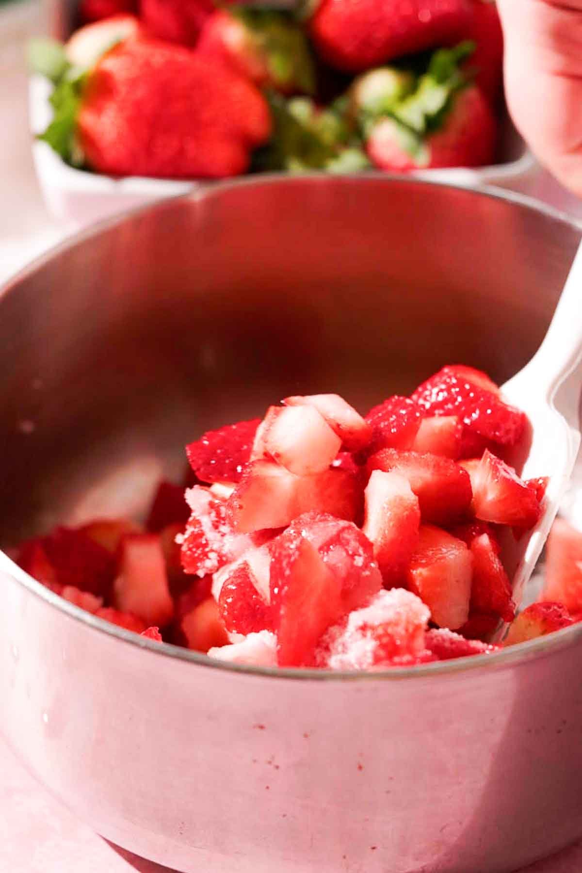stir chopped strawberries with sugar in saucepan