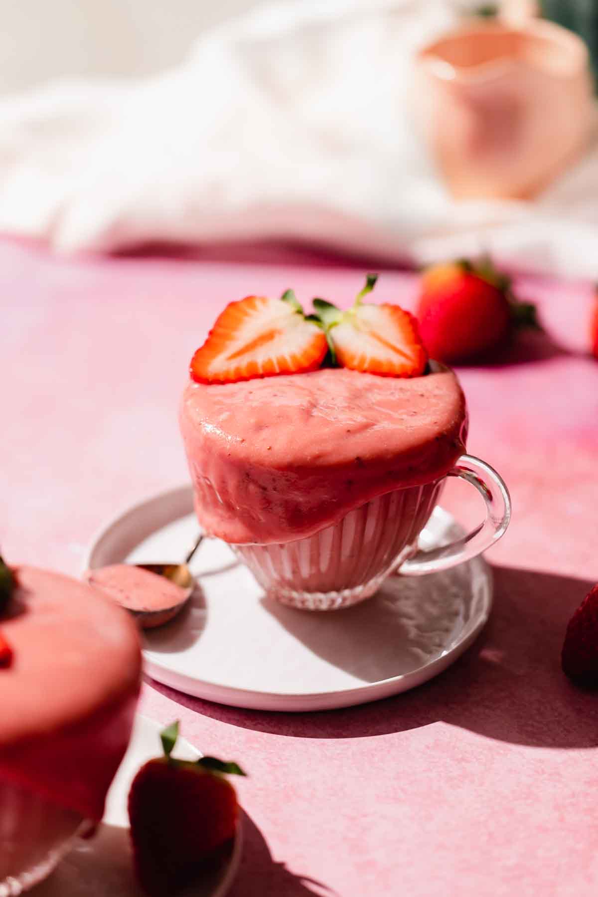 strawberry curd in a cup with fresh strawberries on top