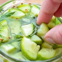 Picking a spear of Instant Pot Pickles out of a glass jar.