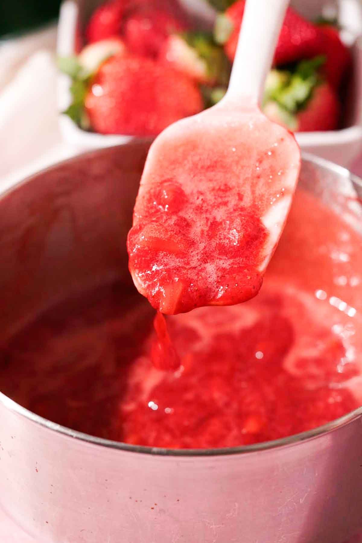 stirring thickened strawberry sauce with rubber spatula
